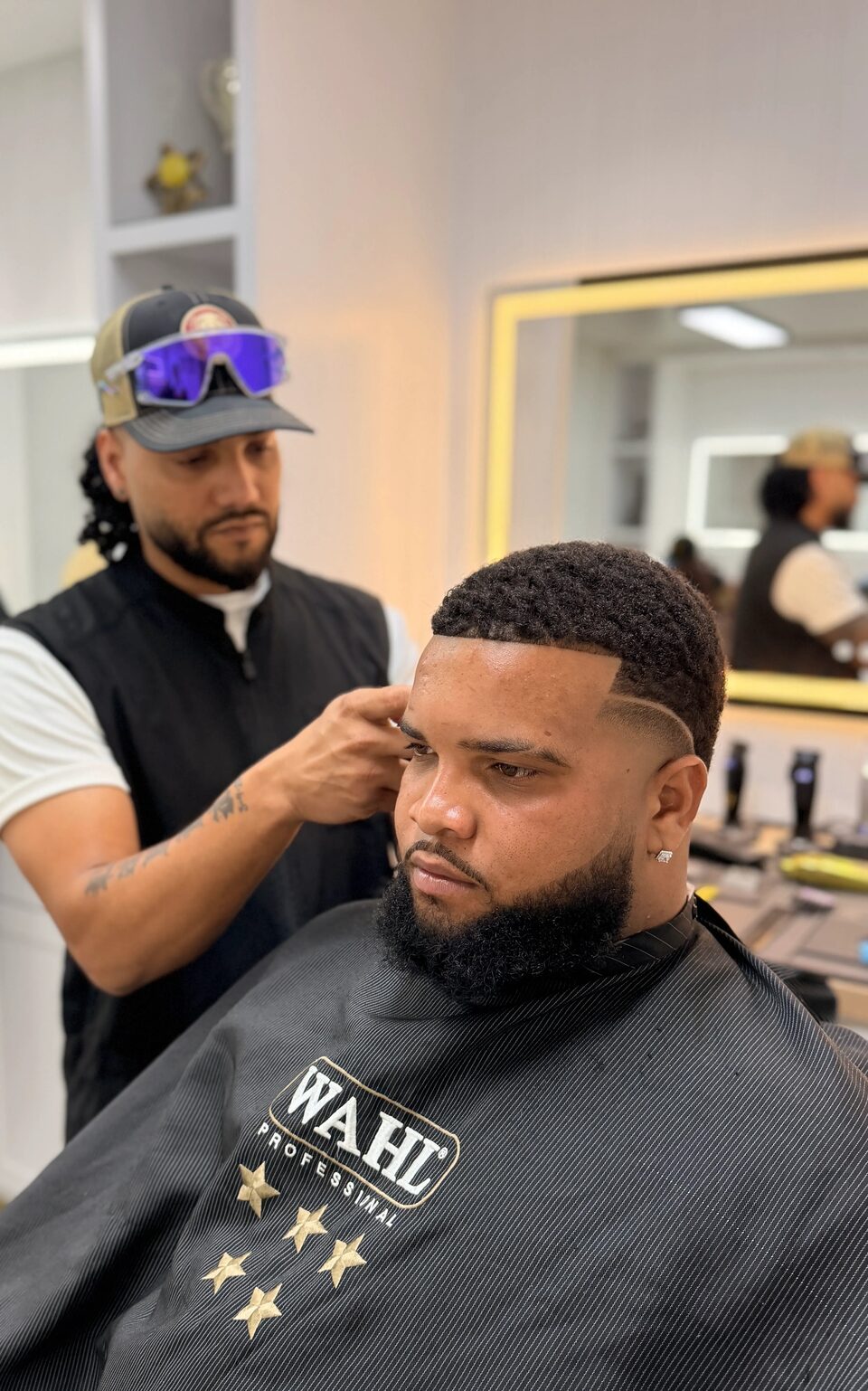 A barber adding the finishing touches around a client's temple