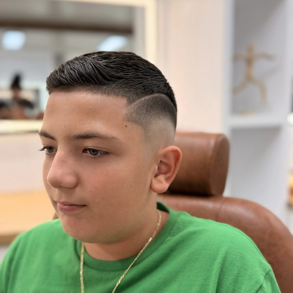 A young client with a neatly styled side part and tapered sides