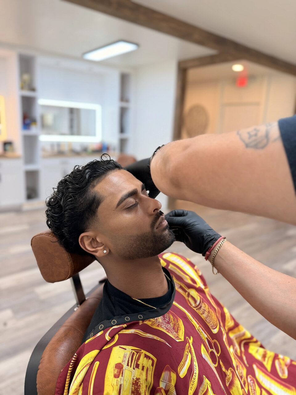 A client reclining in a leather chair during a beard grooming service